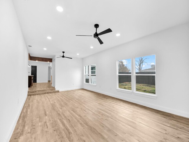 unfurnished living room featuring ceiling fan and light wood-type flooring