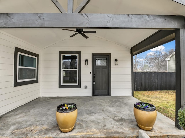 view of exterior entry featuring ceiling fan and a patio area