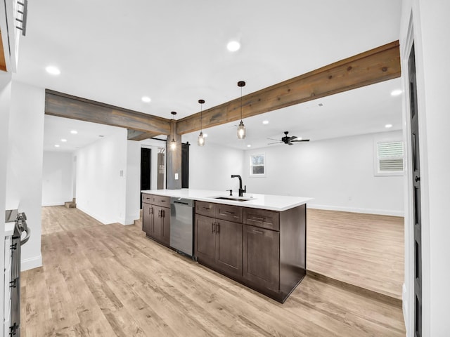 kitchen with sink, hanging light fixtures, a center island with sink, appliances with stainless steel finishes, and beam ceiling