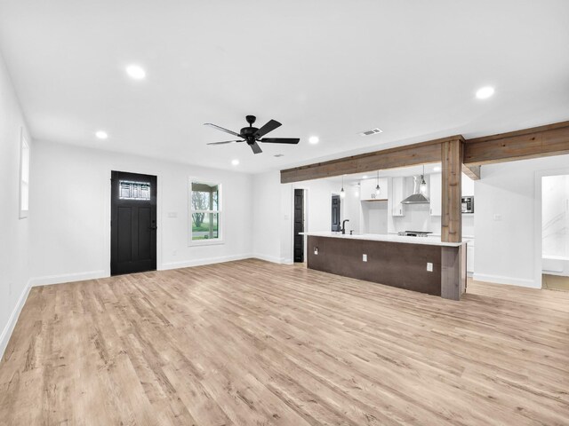 kitchen featuring pendant lighting, white cabinetry, a kitchen island with sink, stainless steel appliances, and dark brown cabinetry