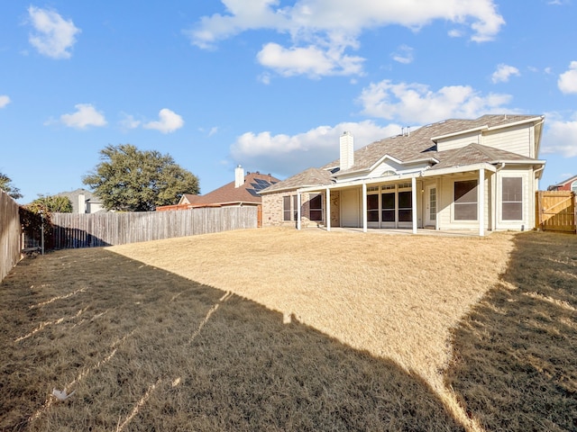 rear view of property featuring a lawn