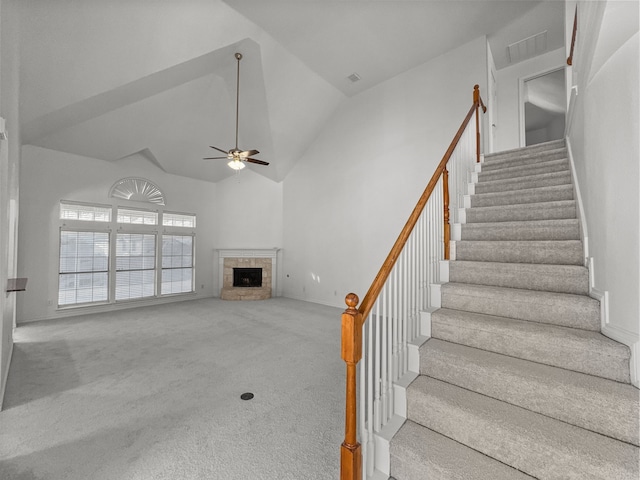 carpeted living room with ceiling fan and high vaulted ceiling