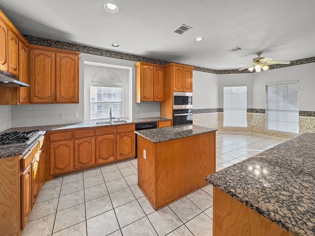 kitchen featuring sink, light tile patterned floors, ceiling fan, appliances with stainless steel finishes, and a kitchen island