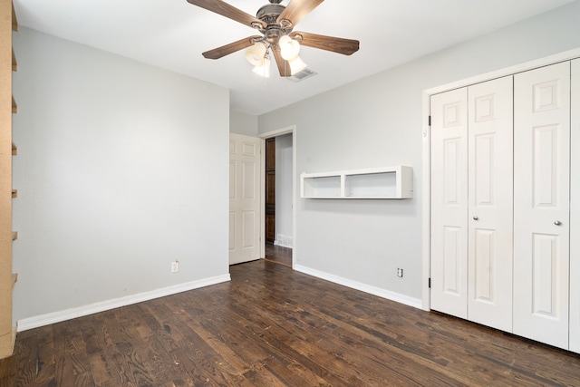 unfurnished bedroom featuring a closet, dark hardwood / wood-style floors, and ceiling fan