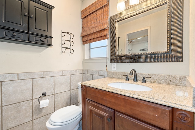 bathroom with vanity, toilet, and tile walls