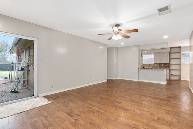 unfurnished living room featuring hardwood / wood-style flooring and ceiling fan