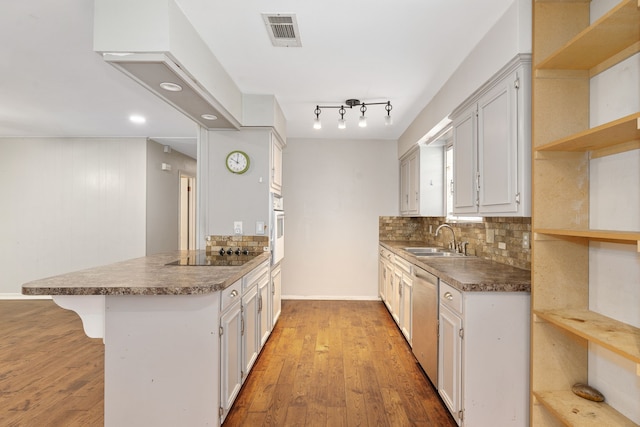 kitchen featuring white cabinetry, black electric cooktop, kitchen peninsula, and white oven