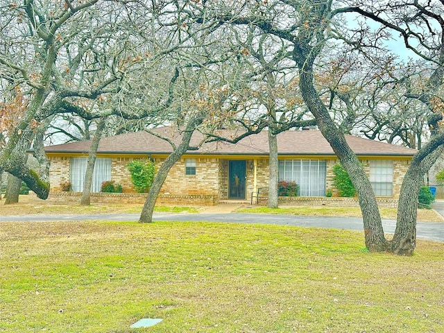 view of front of house featuring brick siding, aphalt driveway, and a front yard