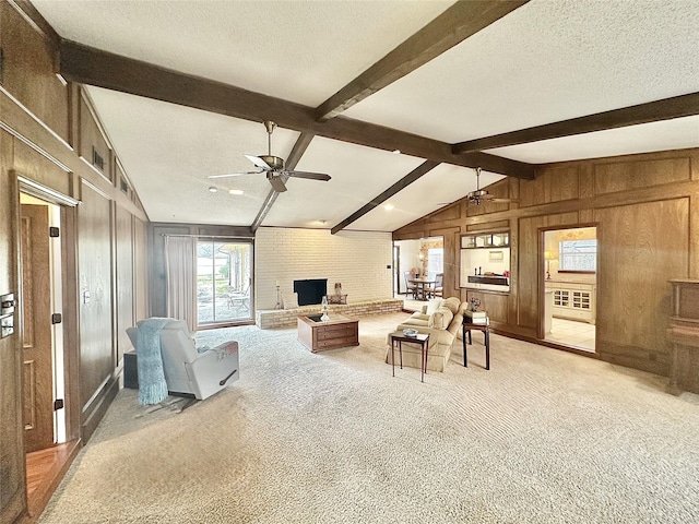 living area with light colored carpet, ceiling fan, wooden walls, and a textured ceiling