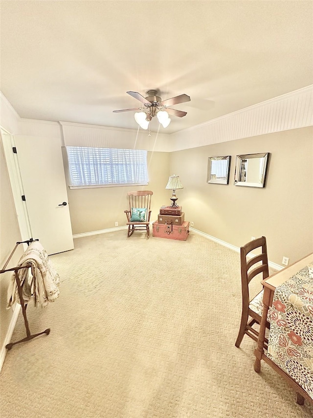 living area with carpet floors, a wealth of natural light, baseboards, and a ceiling fan