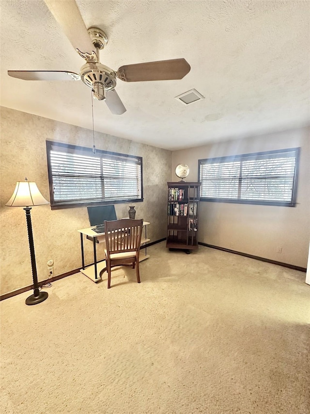 living area with visible vents, baseboards, ceiling fan, a textured ceiling, and carpet flooring