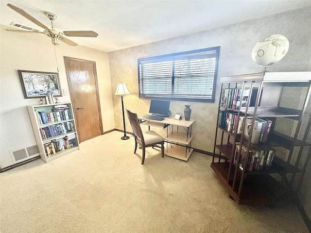 carpeted office space featuring visible vents, ceiling fan, and baseboards