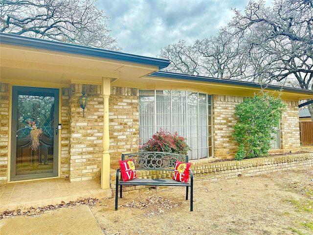 view of exterior entry with brick siding