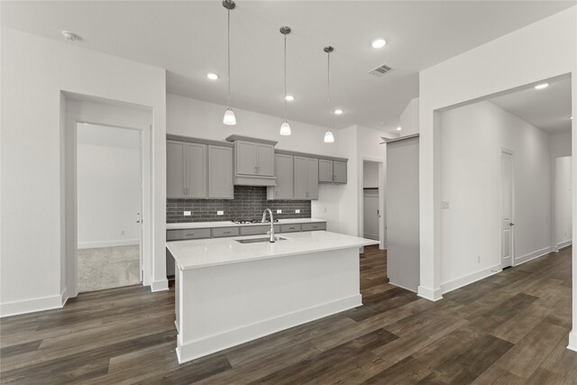 7221 Ladybug, Little Elm, TX 76227 - kitchen featuring gray cabinetry, light countertops, a kitchen island with sink, backsplash, and a sink