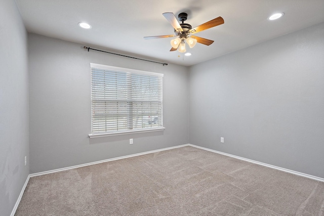 empty room featuring ceiling fan and carpet