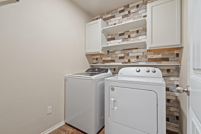 washroom with cabinets and washing machine and clothes dryer