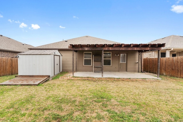 rear view of property with a patio, a yard, and a storage shed