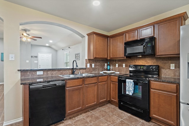 kitchen featuring sink, dark stone countertops, decorative backsplash, and black appliances