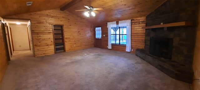 unfurnished living room with a fireplace, carpet floors, wooden walls, and lofted ceiling with beams