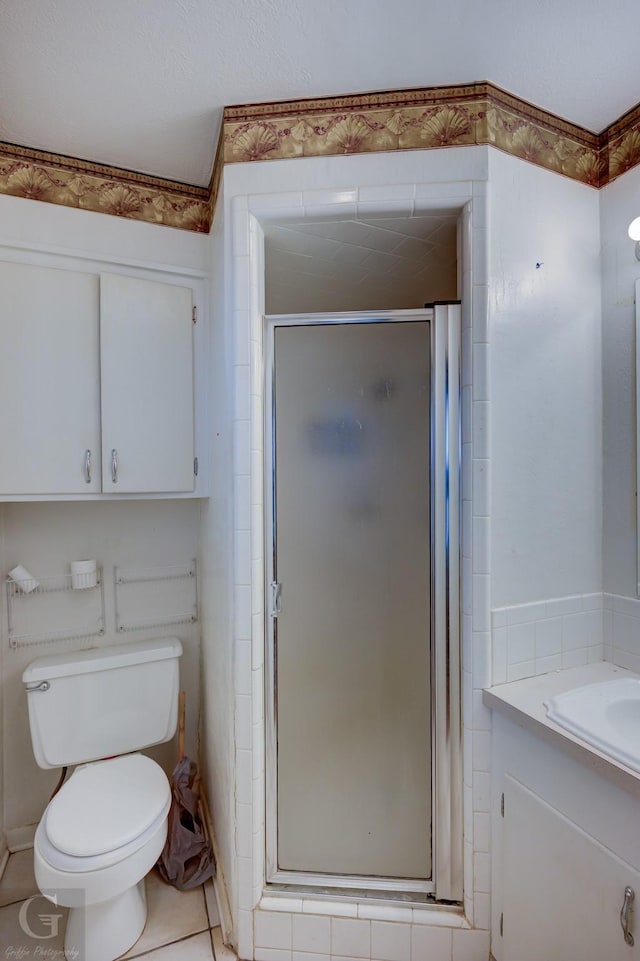 bathroom with tile patterned floors, vanity, toilet, and a shower with door