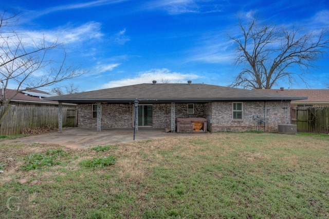 rear view of house featuring cooling unit, a patio area, and a lawn