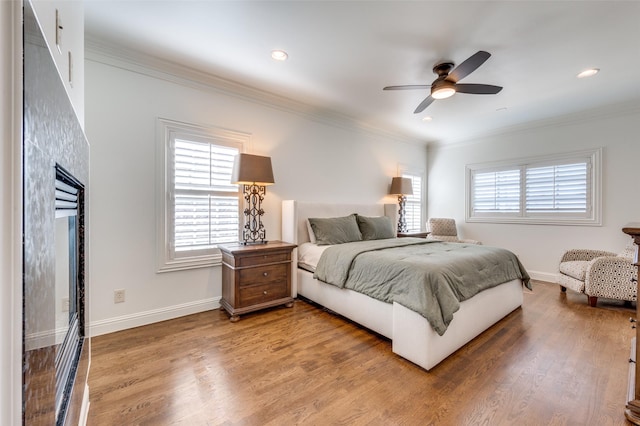 bedroom with crown molding, wood-type flooring, and ceiling fan