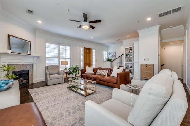 living room featuring crown molding, dark hardwood / wood-style floors, ceiling fan, and a fireplace