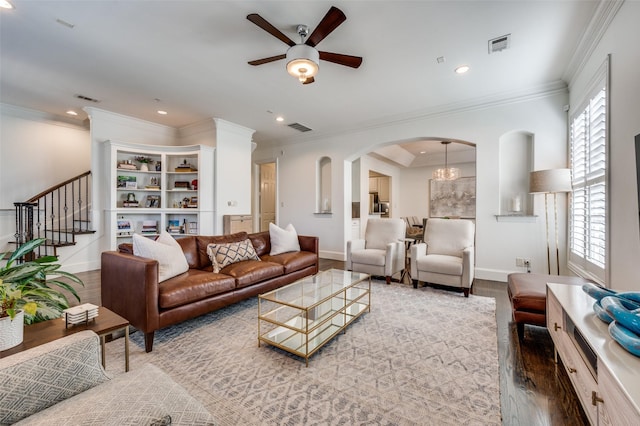 living room with crown molding, plenty of natural light, ceiling fan with notable chandelier, and wood-type flooring