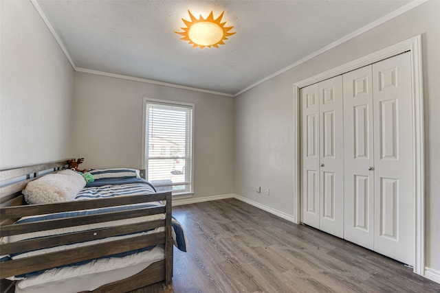 bedroom with crown molding, wood-type flooring, and a closet