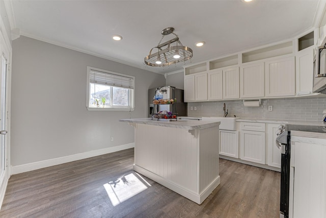 kitchen with decorative light fixtures, white cabinets, backsplash, a center island, and stainless steel appliances