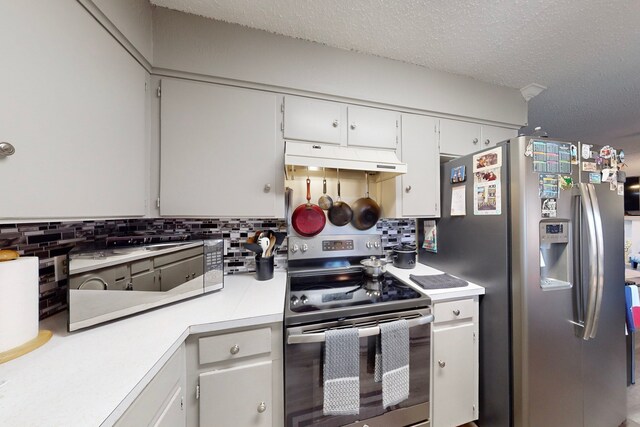 kitchen with backsplash, a textured ceiling, stainless steel appliances, and white cabinets