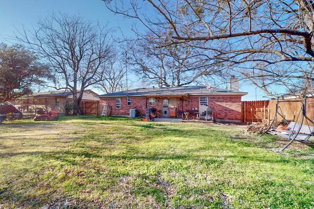 back of property with cooling unit and a lawn