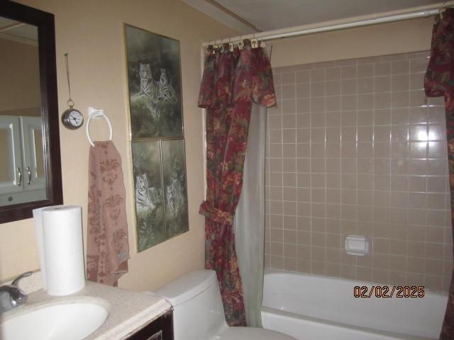 full bathroom featuring shower / tub combo, vanity, and toilet