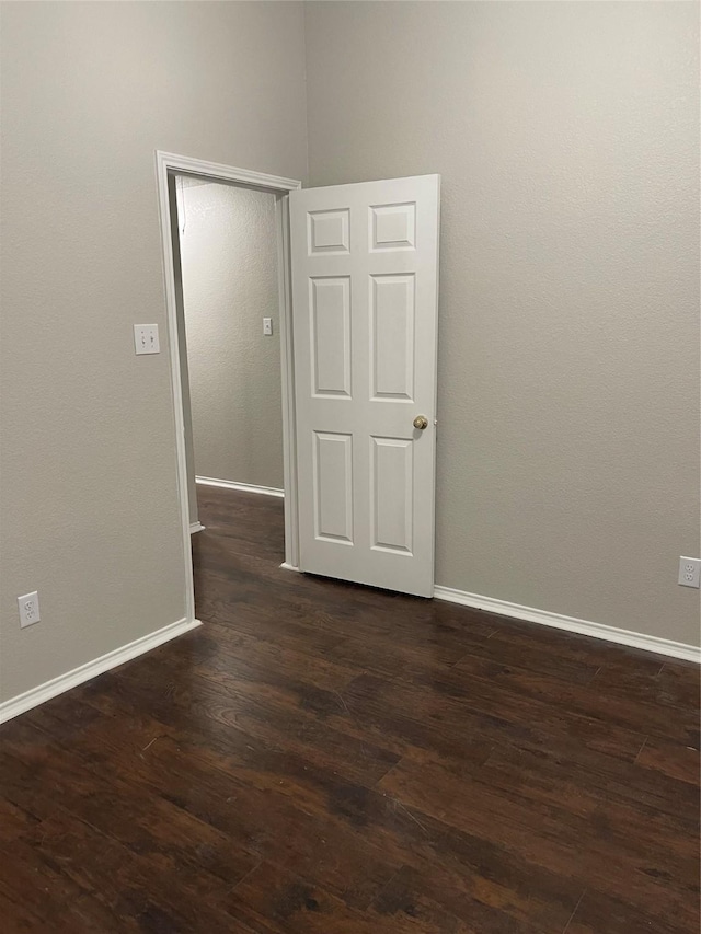 empty room with dark hardwood / wood-style flooring