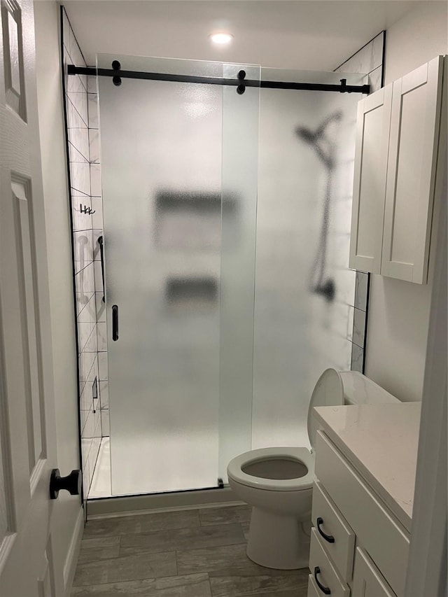 bathroom with vanity, wood-type flooring, toilet, and walk in shower