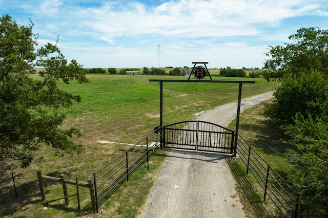 view of gate featuring a rural view and a yard