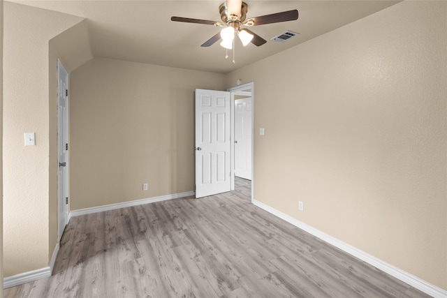 empty room with ceiling fan and light hardwood / wood-style flooring