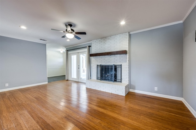 unfurnished living room featuring hardwood / wood-style flooring, a fireplace, ornamental molding, and ceiling fan