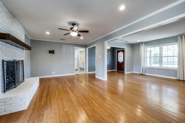 unfurnished living room featuring ornamental molding, light wood-type flooring, ceiling fan, and a fireplace