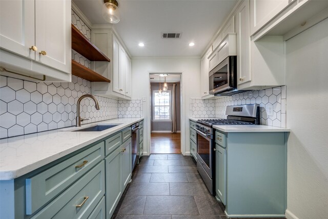 kitchen featuring sink, white cabinetry, stainless steel appliances, light stone countertops, and backsplash