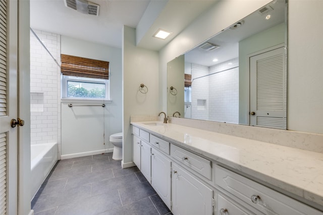 full bathroom featuring tile patterned flooring, vanity, tiled shower / bath, and toilet