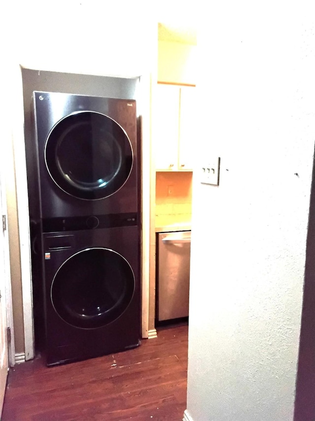 clothes washing area with stacked washing maching and dryer and dark hardwood / wood-style flooring