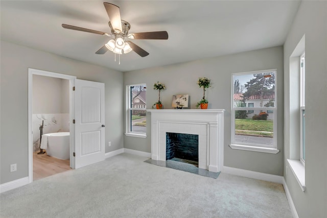 unfurnished living room with plenty of natural light, light colored carpet, and ceiling fan