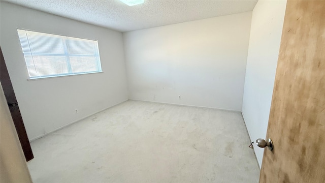 carpeted spare room with a textured ceiling