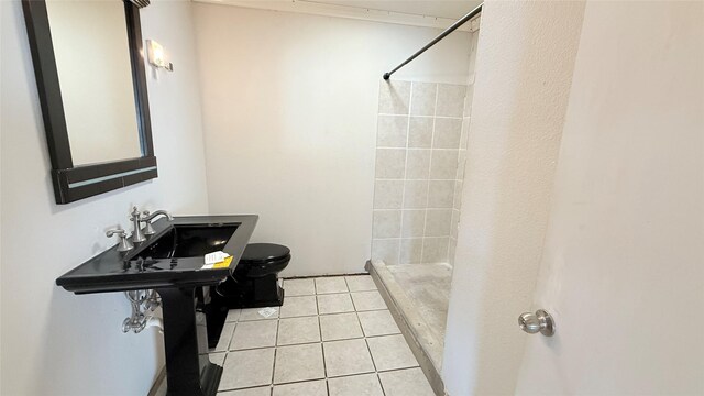 bathroom featuring sink, tile patterned floors, toilet, and tiled shower