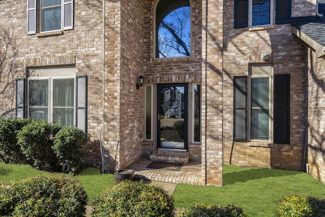 doorway to property with a lawn