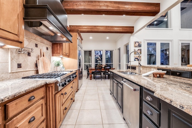 kitchen with light stone countertops, sink, custom range hood, appliances with stainless steel finishes, and beamed ceiling