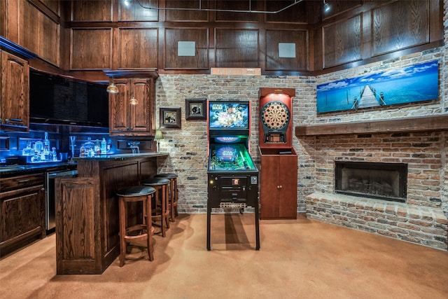 bar featuring a brick fireplace, a center island, dark brown cabinets, light carpet, and a breakfast bar area