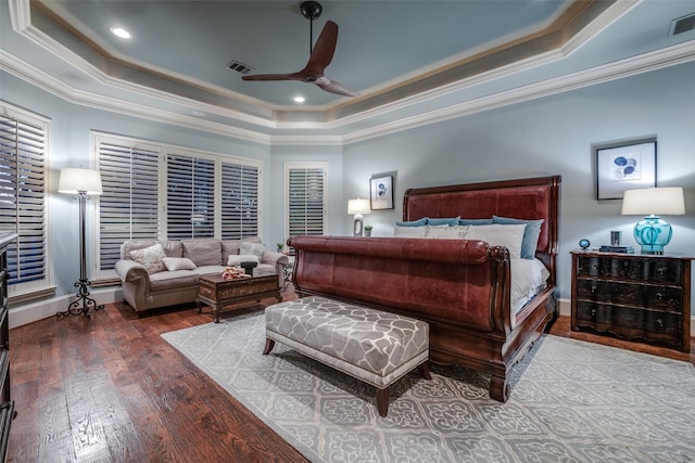 bedroom featuring a tray ceiling, ornamental molding, ceiling fan, and hardwood / wood-style flooring