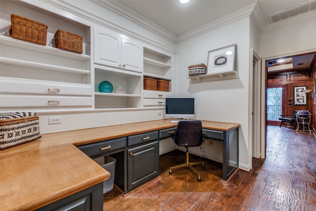 office featuring built in desk, dark wood-style flooring, built in features, visible vents, and ornamental molding